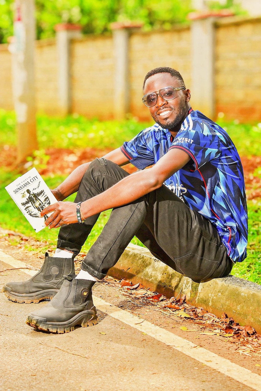 Natembea Wangwe holding a copy of The Tales of Sunkiana City